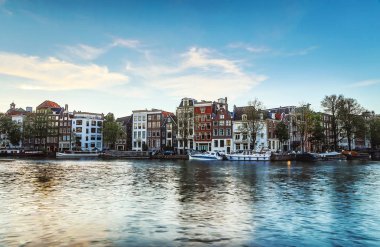 En ünlü kanallar ve bentleri Amsterdam City günbatımı sırasında. Cityscape ve geleneksel Hollanda mimarisinin genel görünümü.