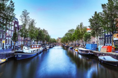 En ünlü kanallar ve bentleri Amsterdam City günbatımı sırasında. Cityscape ve geleneksel Hollanda mimarisinin genel görünümü.