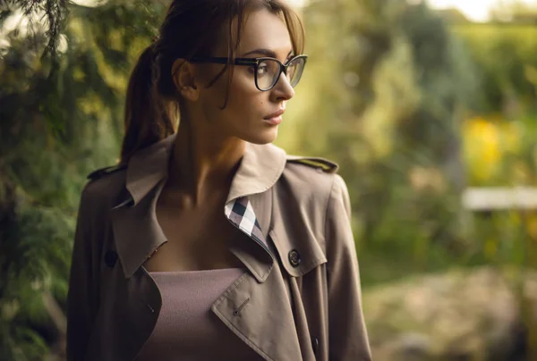 Porträt einer schönen jungen Frau mit Brille im herbstlichen Garten. — Stockfoto