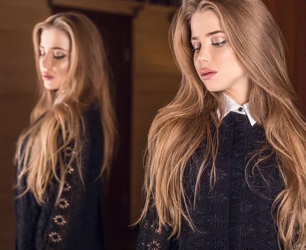 Elegante joven mujer de belleza en vestido de lujo posando en interiores contra espejo . — Foto de Stock