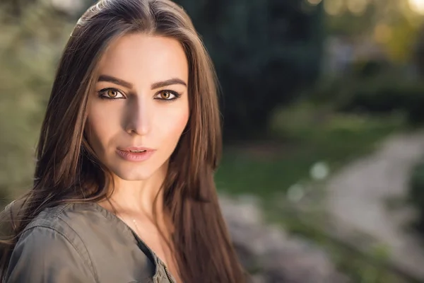 Outdoors portrait of beautiful young woman in casual clothes posing in autumn garden. — Stock Photo, Image