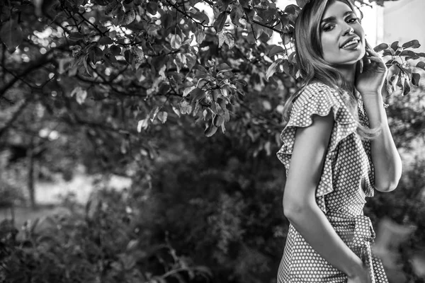 Außenporträt einer schönen jungen Frau, die im herbstlichen Garten posiert. Schwarz-Weiß-Foto. — Stockfoto