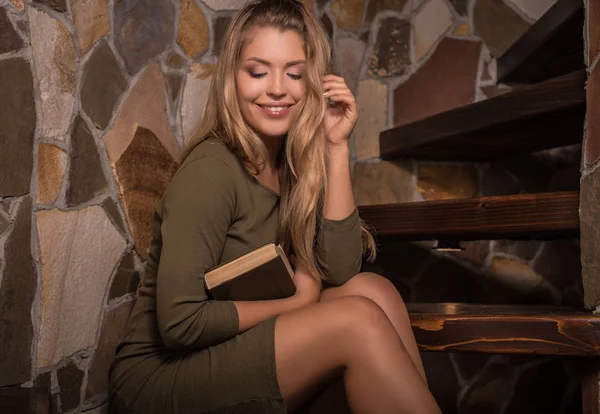 Jeune femme de beauté souriante avec livres contre l'intérieur de la maison . — Photo