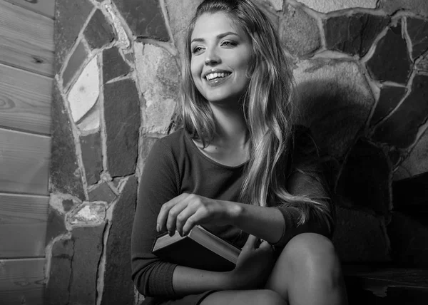 Giovane donna di bellezza sorridente con libri contro gli interni della casa . — Foto Stock
