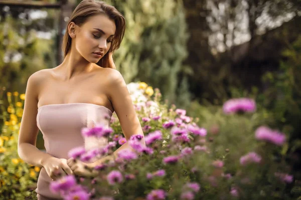 Utomhus porträtt av vacker ung kvinna i casual kläder poserar i höst trädgård. — Stockfoto
