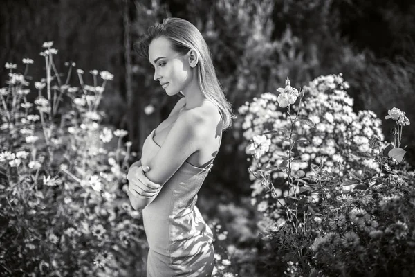 Außenporträt einer schönen jungen Frau, die im herbstlichen Garten posiert. Schwarz-Weiß-Foto. — Stockfoto