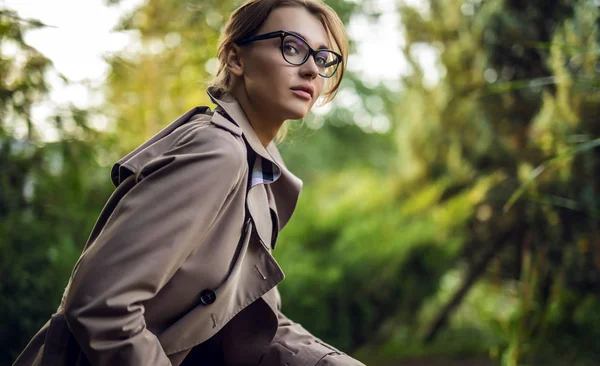 Utomhus porträtt av vacker ung kvinna i casual kläder poserar i höst trädgård. — Stockfoto