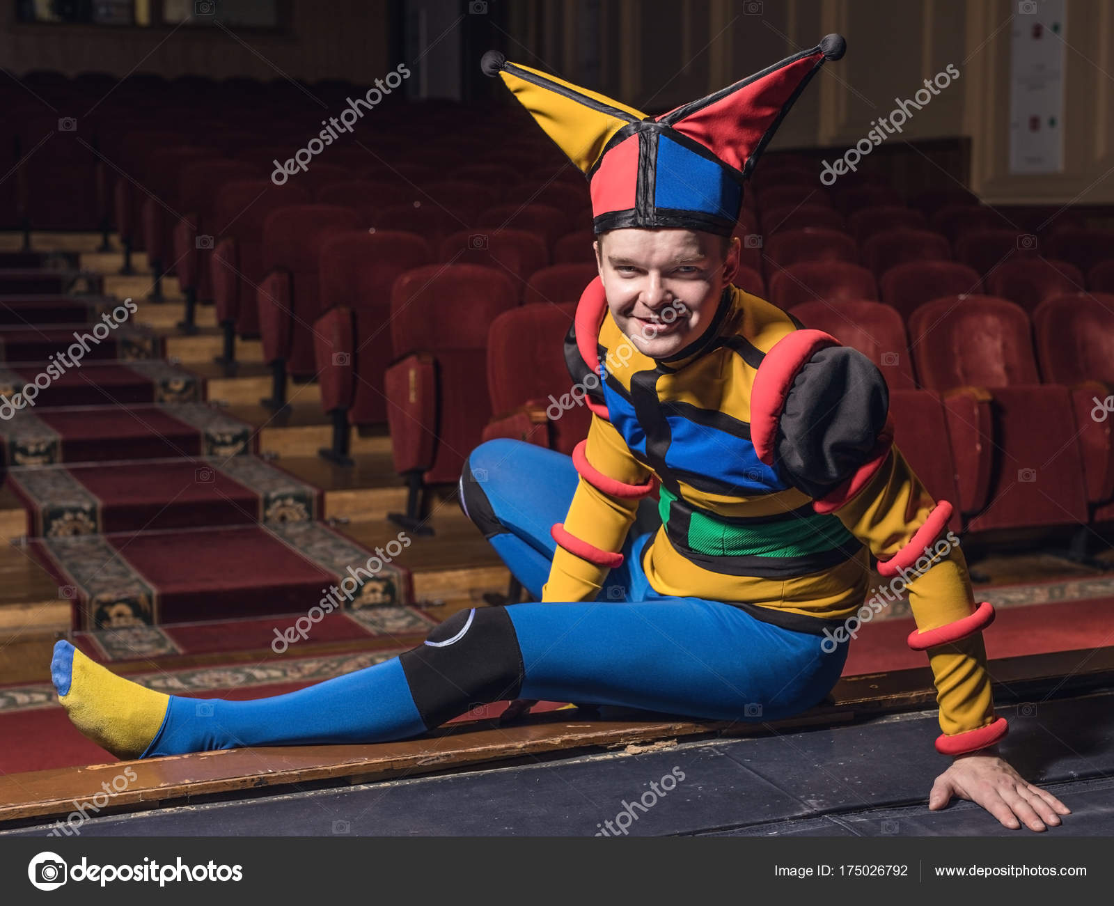 Actor dressed jester's costume in interior of old theater. Stock Photo