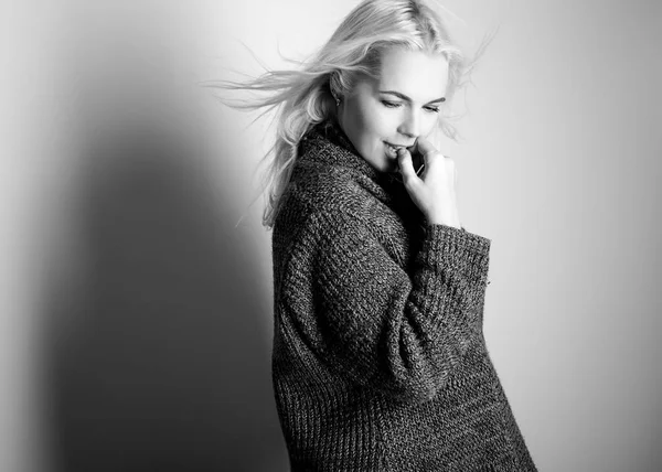 Jeune modèle blond sensuel dans une pose de pull tricoté en studio. Photo noir-blanc . — Photo