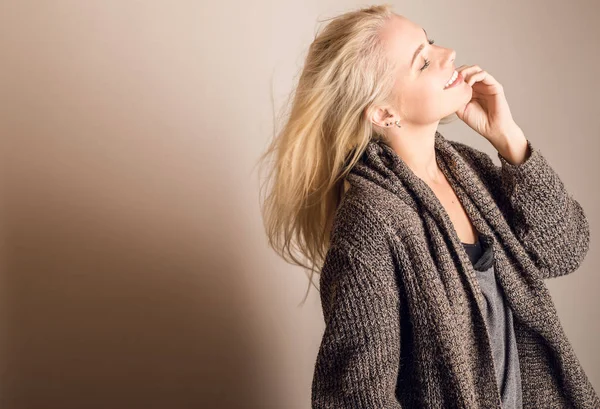 Giovane bionda modello sensuale in un maglione a maglia posa in studio . — Foto Stock