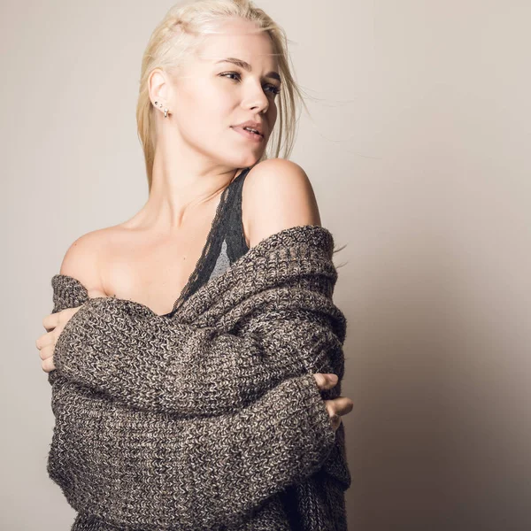 Молода блондинка чуттєва модель в трикотажному светрі в студії . — стокове фото