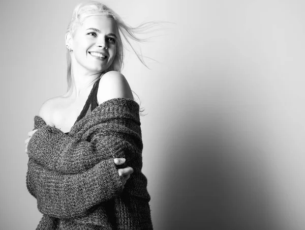 Νεαρό ξανθιά αισθησιακή μοντέλο σε ένα πλεκτό πουλόβερ θέτουν στο studio. Ασπρόμαυρη φωτογραφία. — Φωτογραφία Αρχείου