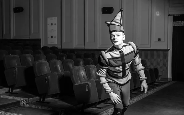 Ηθοποιός ντυμένος στολή του γελωτοποιού στο εσωτερικό του παλιό θέατρο. Μαύρο-άσπρο πορτρέτο. — Φωτογραφία Αρχείου