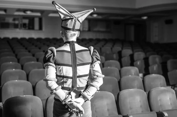Actor vestido traje de bufón en el interior del viejo teatro. Retrato blanco y negro . — Foto de Stock