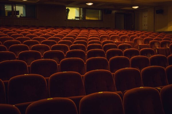 Red armchairs of old theater as conceptual background.