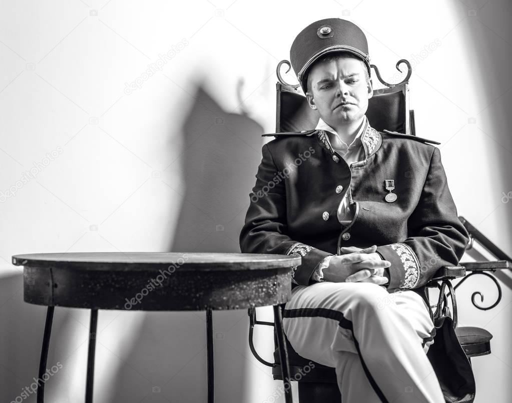 Actor dressed historical costume in interior of old theater. Black-white portrait.