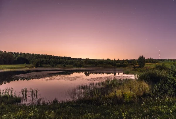 Paisagem noturna em lua cheia e lago sombrio perto da floresta . — Fotografia de Stock