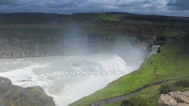 Bir dağ şelale ve İzlanda'daki geleneksel doğa güzel manzara. HD ayak.