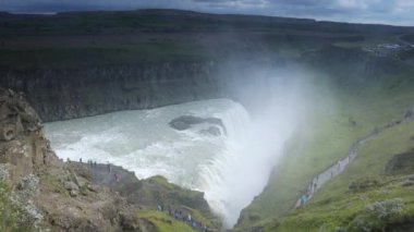 Bir dağ şelale ve İzlanda'daki geleneksel doğa güzel manzara. HD ayak.