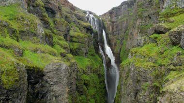 Bir dağ şelale ve İzlanda'daki geleneksel doğa güzel manzara. HD ayak.