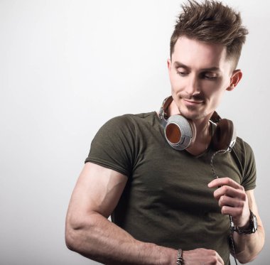 Yeşil t-shirt gri studio arka plan müzik dinleme dostu sportif erkekte yakışıklı.