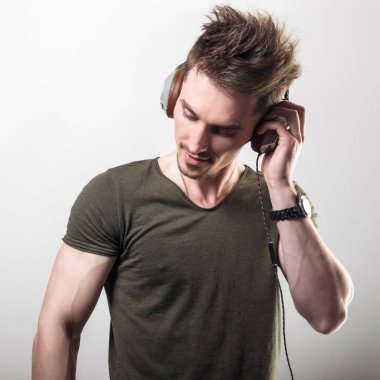 Yeşil t-shirt gri studio arka plan müzik dinleme dostu sportif erkekte yakışıklı.