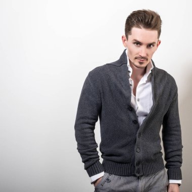 Yakışıklı zarif delikanlı gri switer poz studio arka planı.