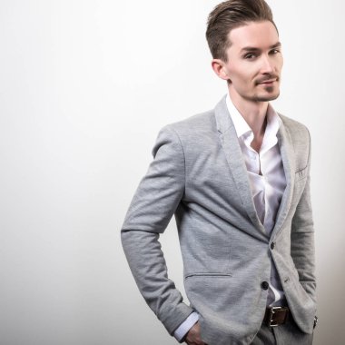Zarif yakışıklı genç gri ceketli poz studio arka planı.