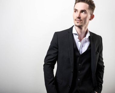 Zarif yakışıklı genç siyah şık klasik kostüm poz studio arka planı.