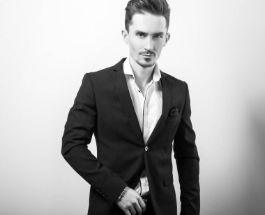 Zarif yakışıklı genç siyah şık klasik kostüm poz studio arka planı.