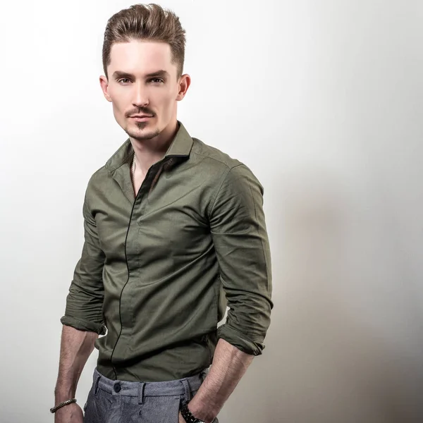 Knappe Elegante Jongeman Groene Shirt Vormen Tegen Grijze Studio Achtergrond — Stockfoto