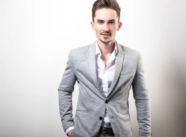 Guapo Joven Elegante Hombre Gris Chaqueta Pose Sobre Fondo Estudio — Foto de Stock