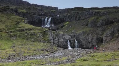 Bir dağ şelale ve İzlanda'daki geleneksel doğa güzel manzara. Ağır çekim görüntüleri.