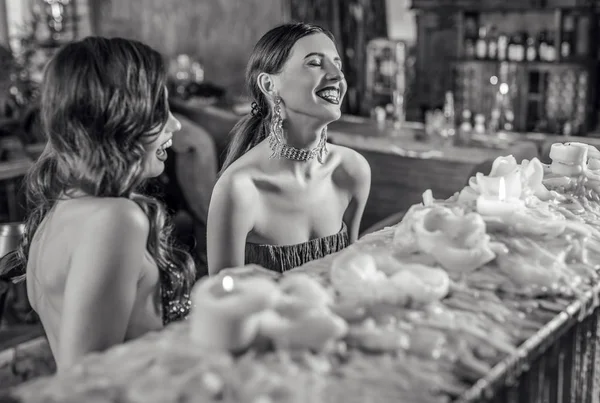 Grupo de jóvenes riendo elegantes chicas vestidas de estilo clásico en el interior del club de lujo. Foto en blanco y negro . —  Fotos de Stock