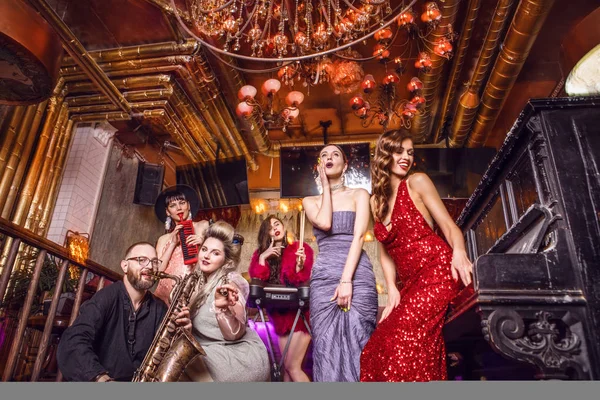 Grupo de jóvenes elegantes vestidos de estilo clásico en el interior del club de lujo . —  Fotos de Stock