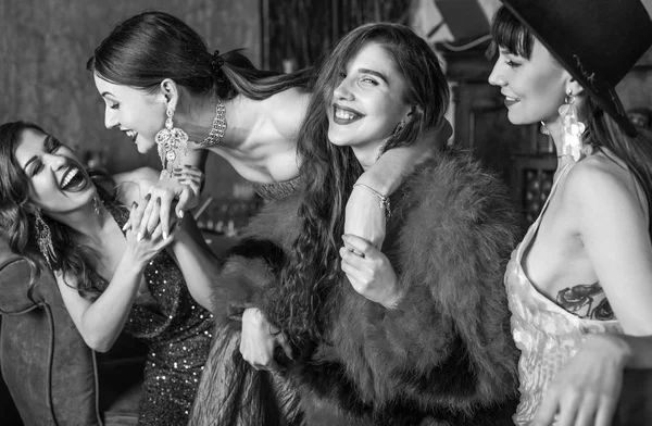 Group of young laughing stylish girls dressed classical style in interior of luxury club. Black-white photo. — Stock Photo, Image