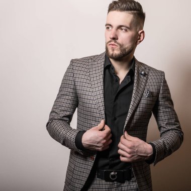 Zarif yakışıklı genç gri ceketli poz studio arka planı.