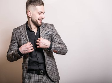 Zarif yakışıklı genç gri ceketli poz studio arka planı.