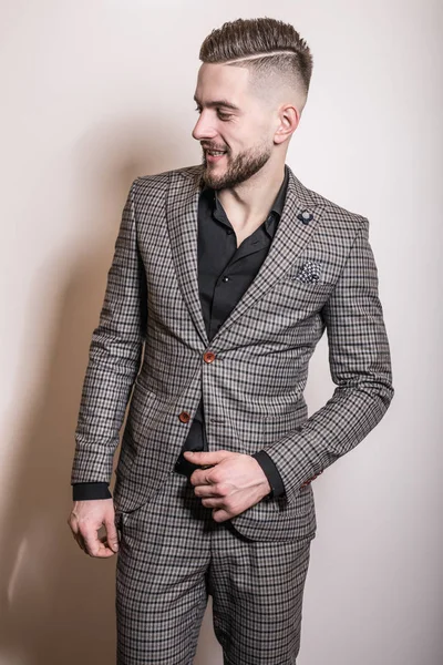 Handsome young elegant man in grey jacket pose against studio background. — Stock Photo, Image