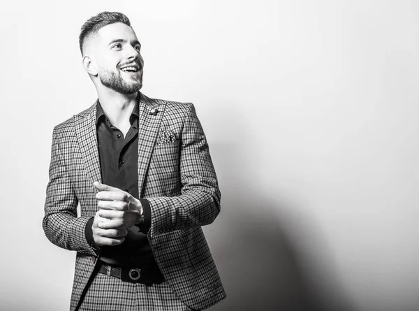 Bonito jovem e elegante homem de jaqueta cinza posar contra o fundo do estúdio. Retrato preto-branco . — Fotografia de Stock