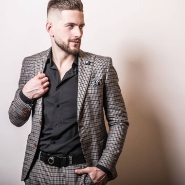 Zarif yakışıklı genç gri ceketli poz studio arka planı.