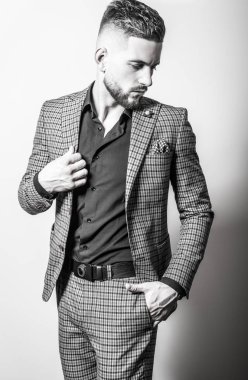 Zarif yakışıklı genç gri ceketli poz studio arka planı. Siyah-beyaz portre.