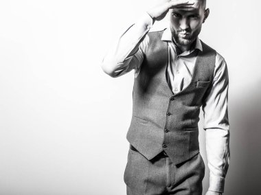 Zarif yakışıklı genç gri klasik yelek içinde poz studio arka planı.