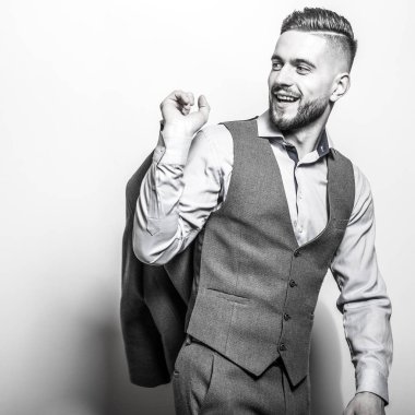 Zarif yakışıklı genç gri klasik yelek içinde poz studio arka planı.