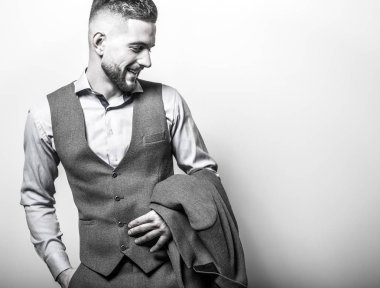 Zarif yakışıklı genç gri klasik yelek içinde poz studio arka planı.