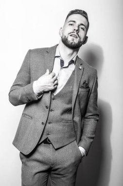 Zarif yakışıklı genç gri ceketli poz studio arka planı. Siyah-beyaz portre.