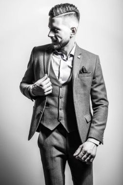 Zarif yakışıklı genç gri ceketli poz studio arka planı. Siyah-beyaz portre.