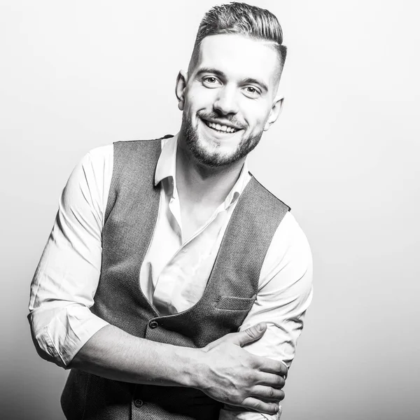 Hombre elegante joven guapo en chaleco clásico gris posan contra fondo de estudio . —  Fotos de Stock