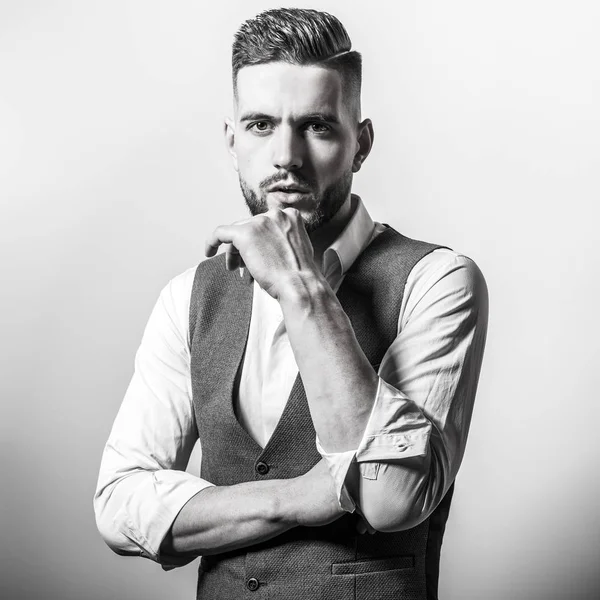 Hombre elegante joven guapo en chaleco clásico gris posan contra fondo de estudio . —  Fotos de Stock