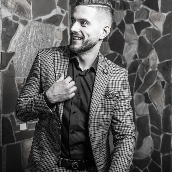 Beau jeune homme élégant pose contre l'intérieur de la maison. Portrait noir-blanc . — Photo